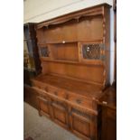 Reproduction stained pine dresser with shelves, small leaded glass cupboards above and three drawers