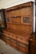 Reproduction stained pine dresser with shelves, small leaded glass cupboards above and three drawers