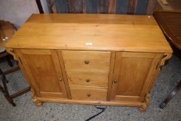 Pine sideboard of two cupboards and three centre drawers on bun feet, approx 109cm wide