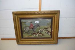 A needlework picture of a huntsman and dogs in gilt frame with moulded ivy decoration