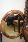 An oval wall mirror with gilt and wooden frame