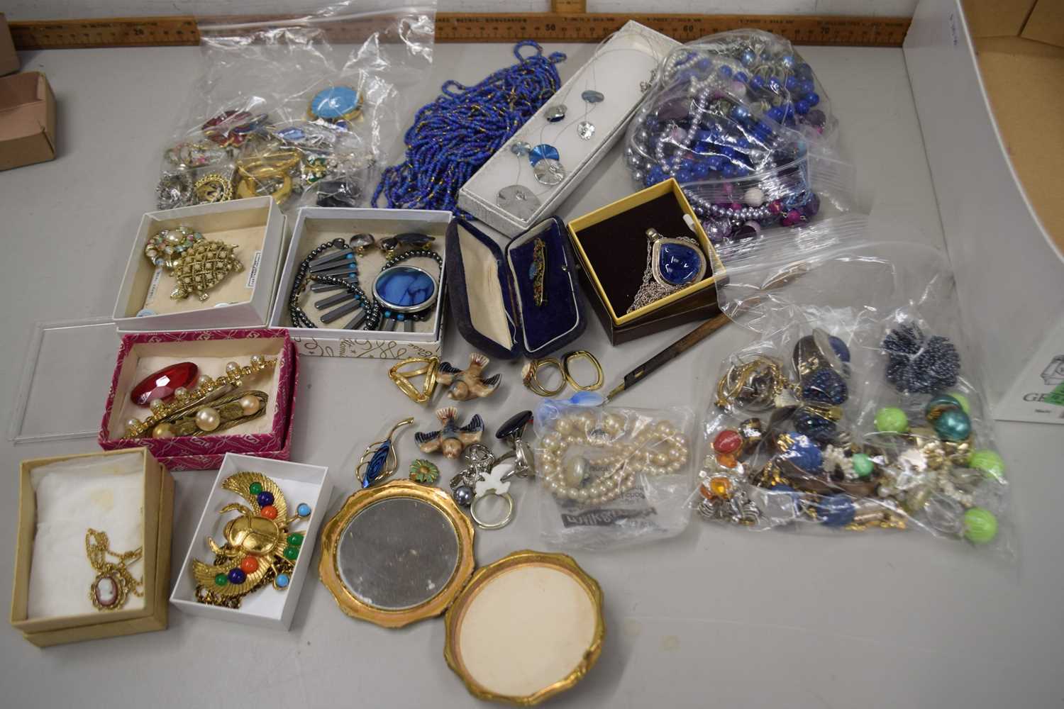 Quantity of assorted costume jewellery to include beads, brooches, faux pearls, compacts etc