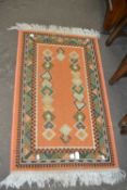 Orange and green rug, approx one metre long