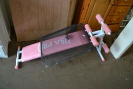 A pink weights bench together with a metal fire guard