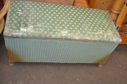 A green wicker blanket box with upholstered seat