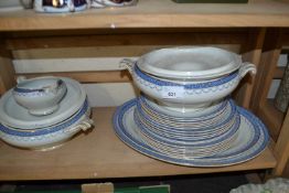 Quantity of dinner wares decorated with blue and gilt borders to include oval serving dishes, dinner