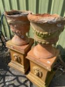 Pair of terracotta pedestals with lion mask detail, 56cm high together with a pair of extremely