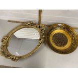 Oval wall mirror in plaster work frame together with a lacquered finish metal fruit bowl