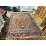 Large Middle Eastern wool floor rug decorated with a central red panel. Approx 2.7m x 3.7m.Carpet
