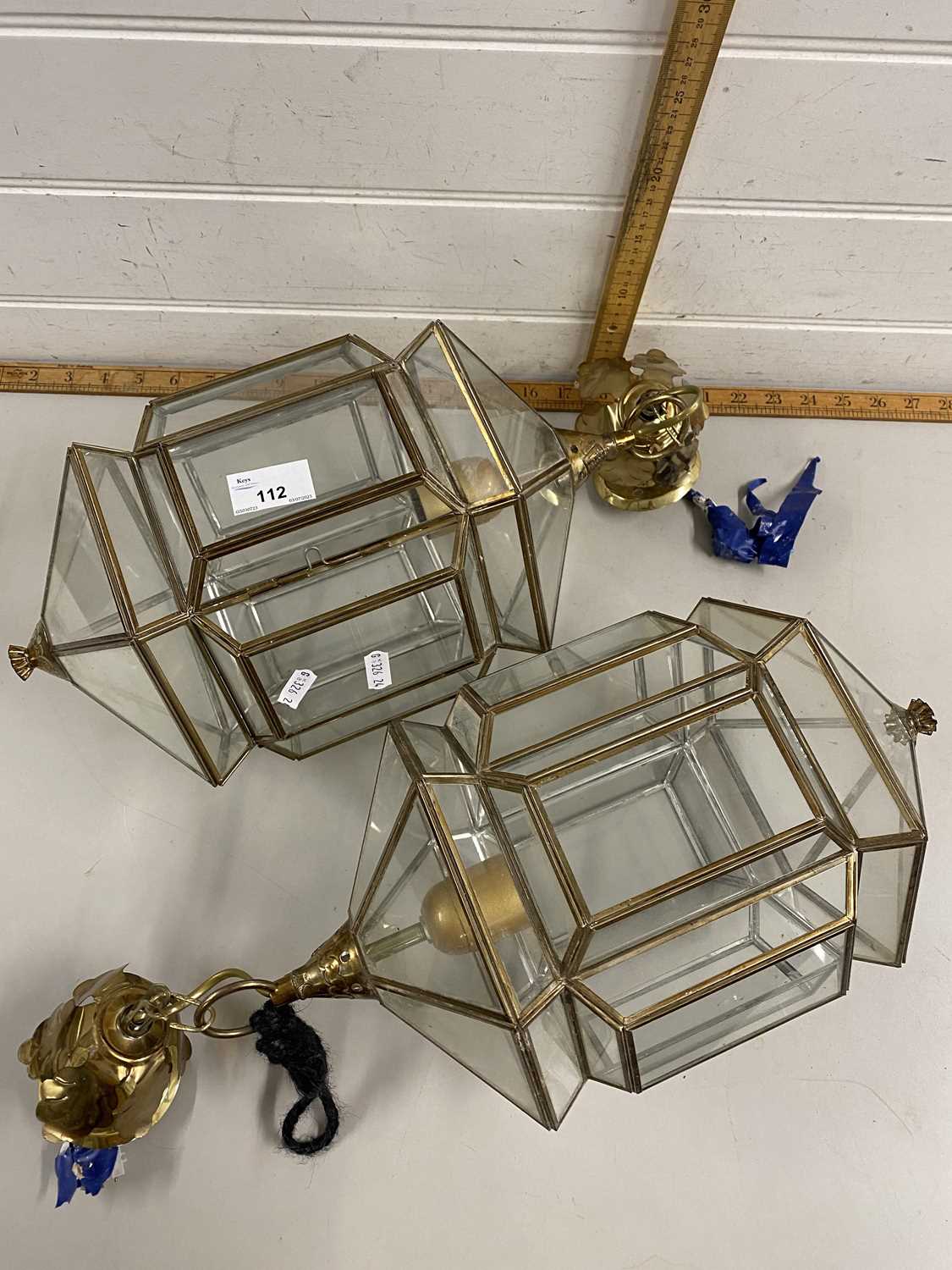 A pair of brass mounted clear glass lanterns