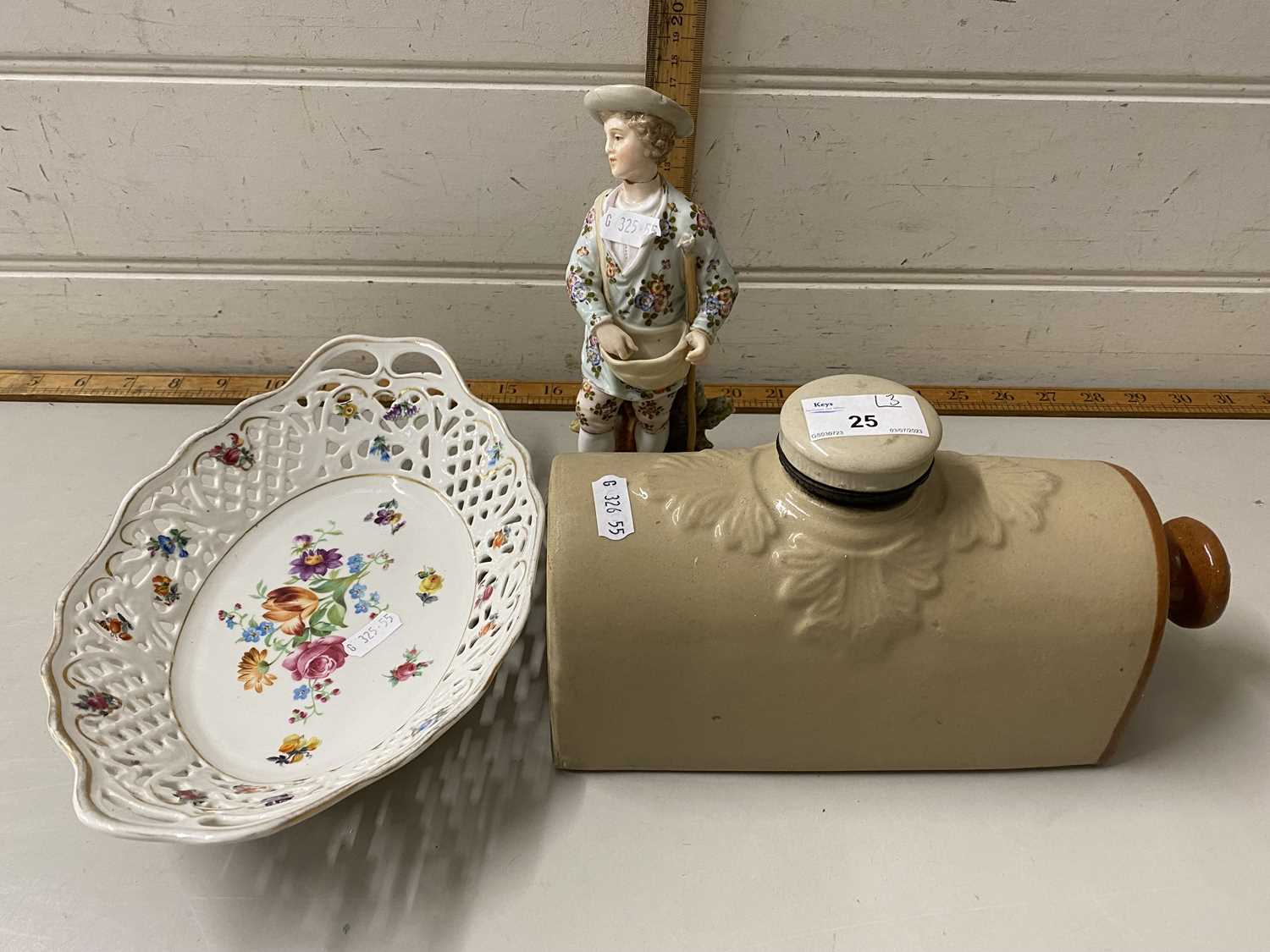 Dresden porcelain basket together with a continental figure and a stone ware hot water bottle (3)