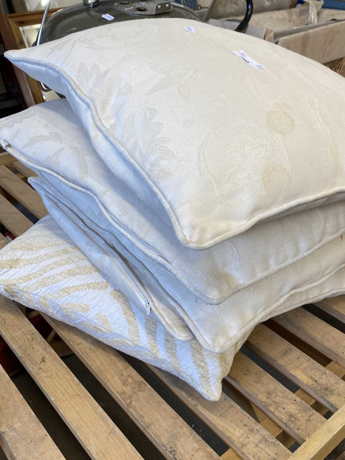 Set of four cream cushions and one other