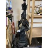 Resin modelled lamp of a seated lady holding a lyre with orange and green trumpet glass shade,