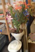 Oval plaster wall plaque together with a pottery bowl and artificial flowers