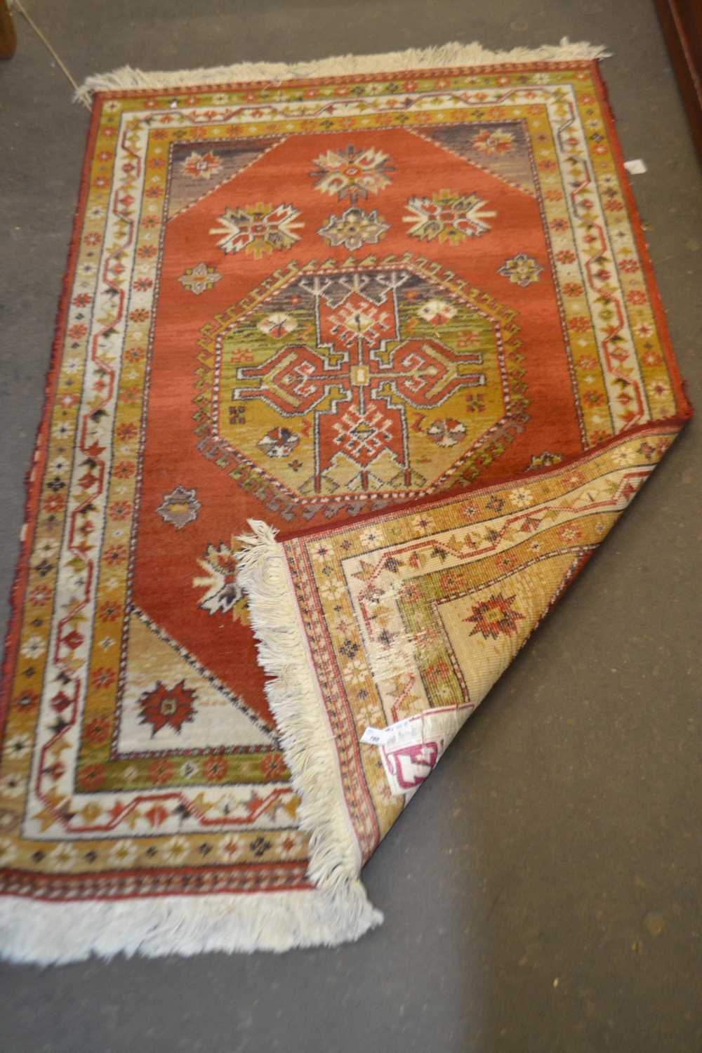 An orange ground rug, approx 155cm long