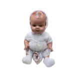 A vintage composite baby doll with green flirty eyes, in white knitted outfit, together with a