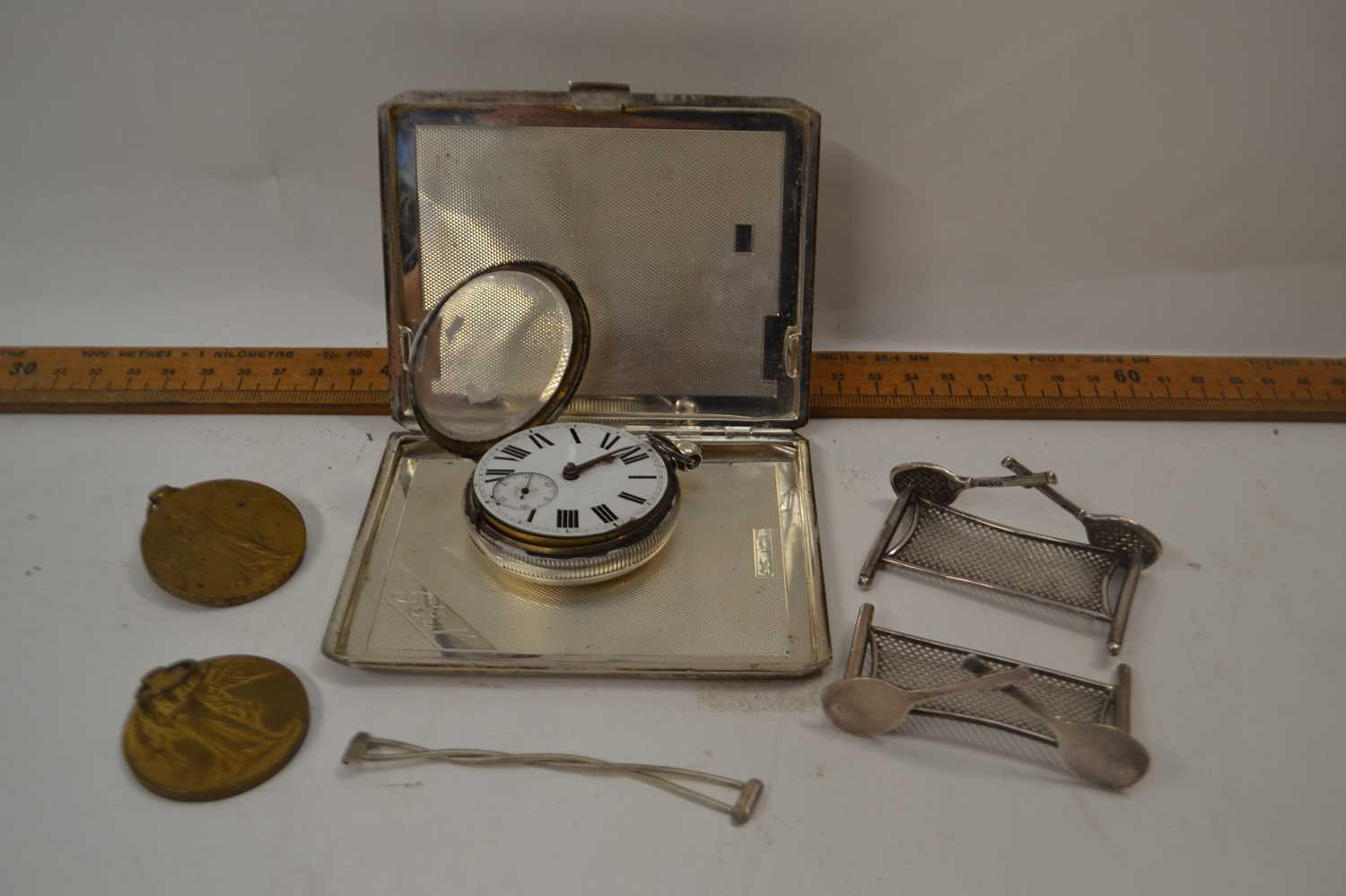 Mixed Lot: A silver cigarette case with engine turned decoration, a pair of small silver knife rests