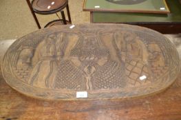 An African oval carved panel, 78cm wide