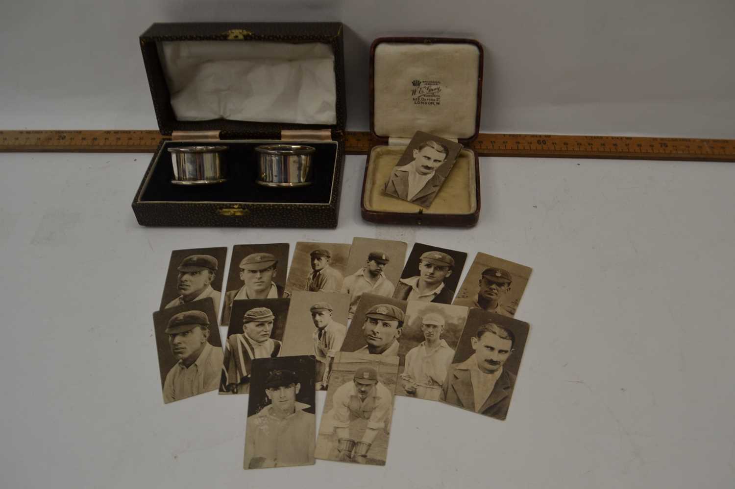 Pair of silver napkin rings together with a small case of cigarette cards