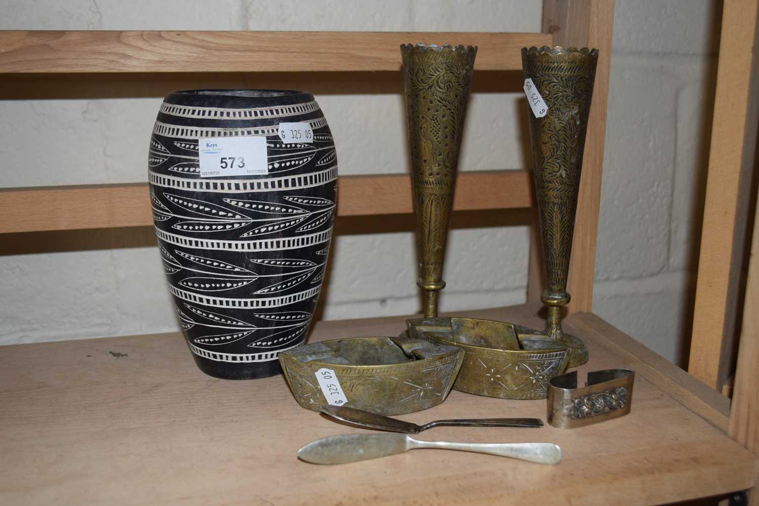 Mixed Lot: Polished stone vase, small white metal napkin ring, butter servers, brass vases, ashtrays