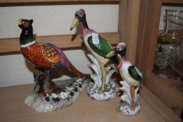 A Royal Crown Derby pheasant together with two models of storks