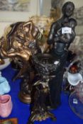 A bronzed resin figure of a man and a woman together with a bronzed style African figure and a