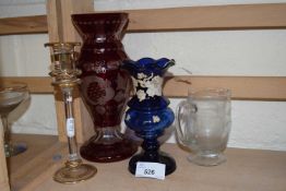 A cranberry glass vase together with other glass ware