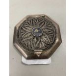 An Egyptian white metal or plated powder compact