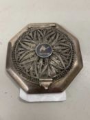 An Egyptian white metal or plated powder compact