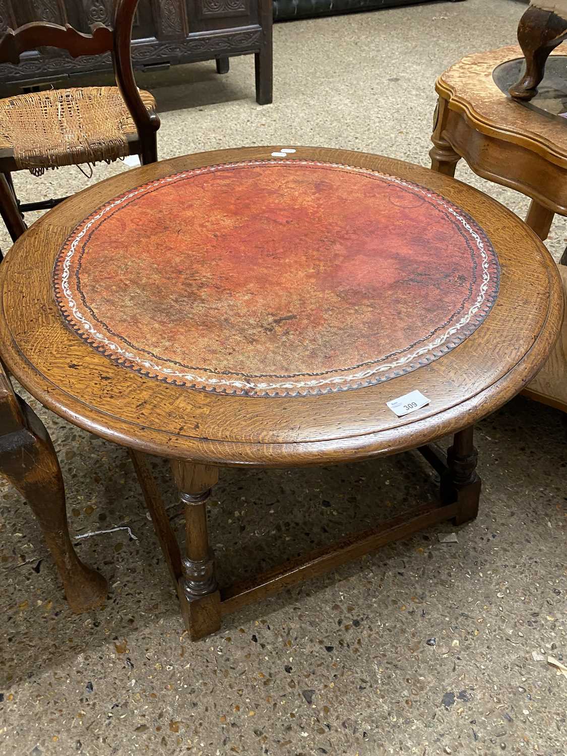 Circular oak topped coffee table with red leather insert