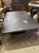 20th Century composition coffee table, the black top decorated with geometric designs, 130cm wide