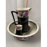 A black glazed and floral decorated three piece wash stand set