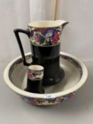 A black glazed and floral decorated three piece wash stand set