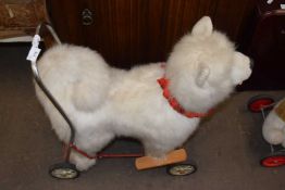 A vintage baby walker / ride on, formed as a husky. Base in rusted condition.