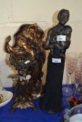 A bronzed resin figure of a man and a woman together with a bronzed style African figure and a