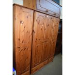 Modern pine wardrobe with three doors, two base drawers and a cupboard to the top together with a