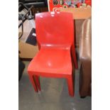 Set of three red plastic Italian stacking chairs