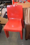 Set of three red plastic Italian stacking chairs