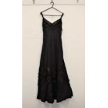 A c.1990's black crepe and lace gown, with velvet straps, lace V-neck with fitted body and long