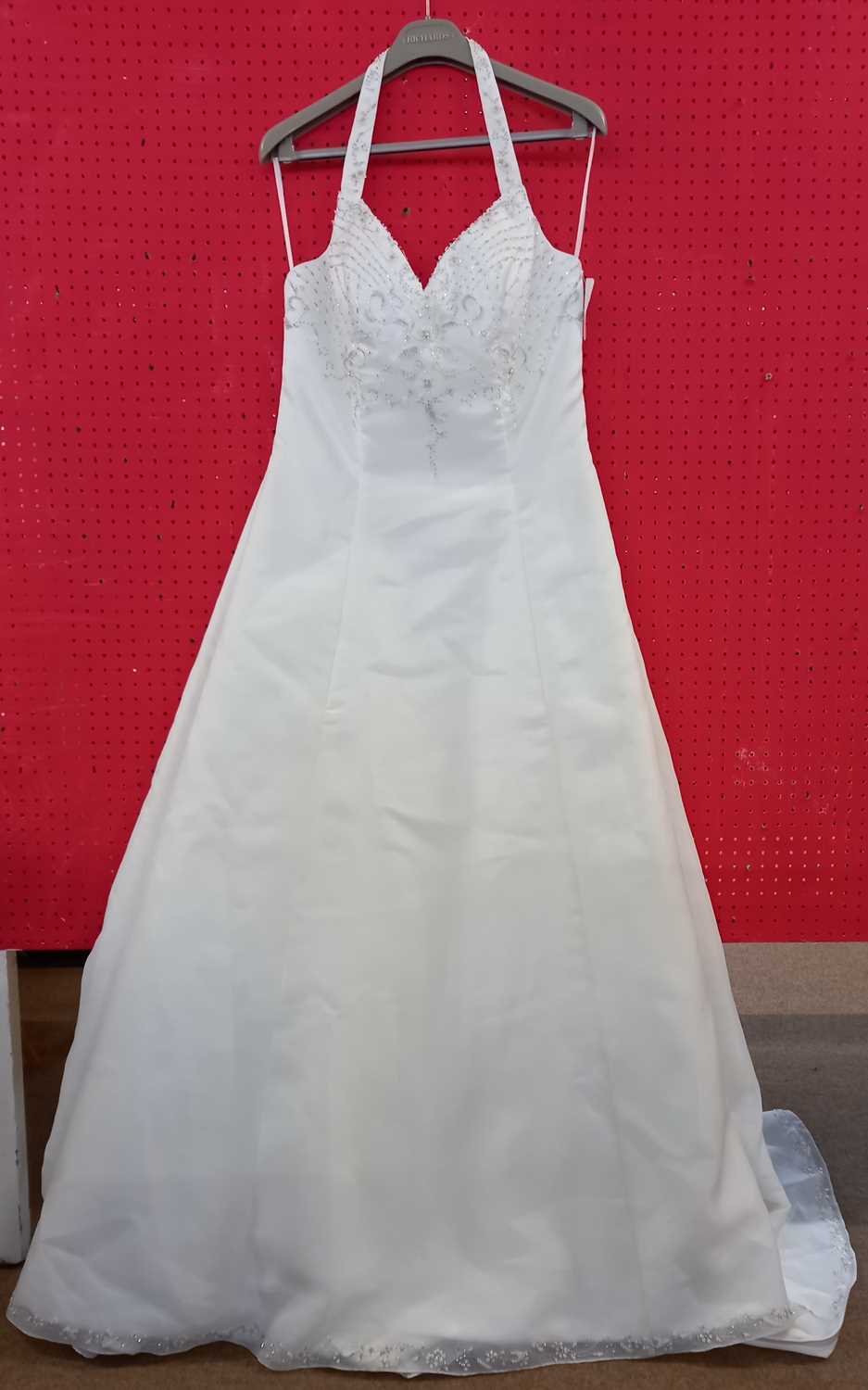 A cream satin halterneck wedding gown, with beaded bodice, chiffon overaly and beaded hemline and