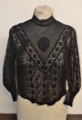 A late 19th / early 20th century black lace blouse, with high neck V-panelled front and all over