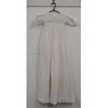 A childrens white cotton christening gown, with broiderie anglaise deocration to top with a deep