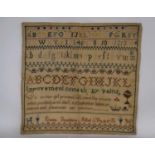 An early 19th century sampler, with polychrome alphabet and numerals, separated by decorative