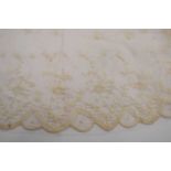 A mid 19th century Coggeshall lace shawl, the fine net with floral decoration and scalloped edge,