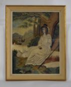A 19th century needlework picture, with woolwork seated lady with painted silk face and hair, with