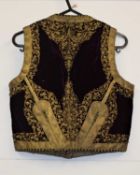 An Islamic/Eastern embroidered waistcoat, with aubergine colour velvet with gold embroidered