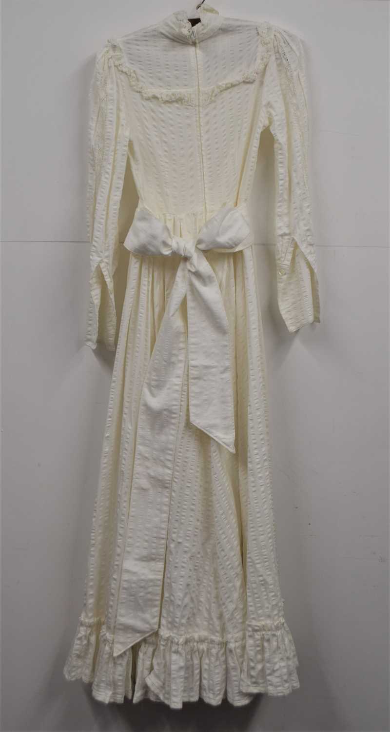 A c.1970's Laura Ashley dress, the full length cream cotton dress with high neck with lace trim, bib - Image 2 of 4