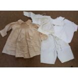 A quantity of vintage childrens clothes to include a cream silk dress with smocking and pale pink