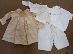 A quantity of vintage childrens clothes to include a cream silk dress with smocking and pale pink
