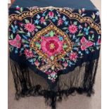 A black silk embroidered shawl, with central pink flower surrounded by floral border and further